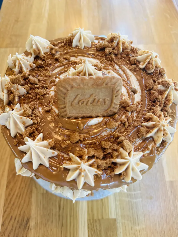 Whole Biscoff cake topped with caramel spread, buttercream stars, biscuit crumb and a Lotus biscuit